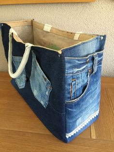 a bag made out of jeans sitting on top of a wooden table