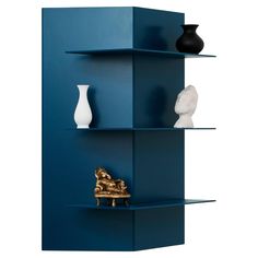 three shelves with vases on them against a blue wall, one shelf has a gold statue and the other is a white sculpture