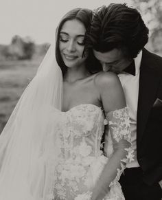 a bride and groom embracing each other in black and white