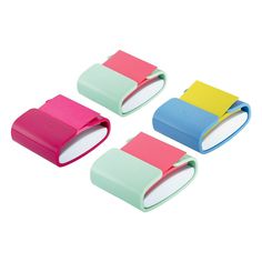 four different colored sticky notes sitting next to each other on a white surface and one has a clip in the middle