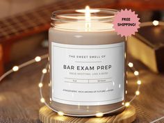 the sweet smell of bar exam prep candle sits on a table next to a guitar