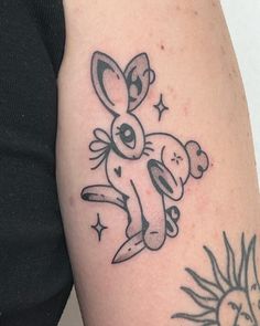 a tattoo on the arm of a woman with a bunny holding a knife in her hand