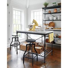 a kitchen island with two stools in front of it and shelves full of dishes