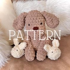 a crocheted stuffed dog sits on a couch next to two little lambs