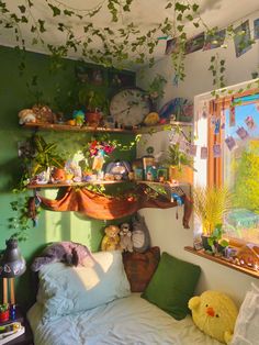 a bedroom with green walls and lots of plants on the shelves above the bed, along with stuffed animals