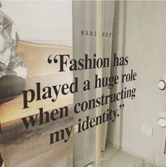 there is a poster on the wall in this bathroom that says fashion has played a huge role when constructing my identity