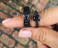 a woman's hand with two rings on it and a car ring in the middle