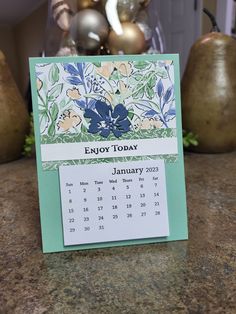 a desk calendar sitting on top of a table next to vases and other decorations