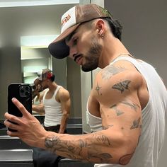 a man is taking a selfie in front of a mirror with his arm tattooed