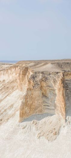 a man standing on top of a sandy hill