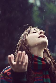 a woman with her eyes closed in the rain