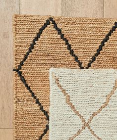 a close up of a rug on the floor with a wooden floor in the background