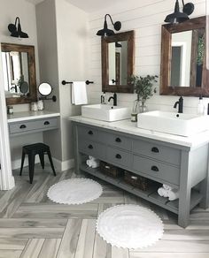 a bathroom with two sinks, mirrors and rugs on the floor in front of them