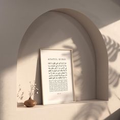 a framed poem on a shelf next to a potted plant