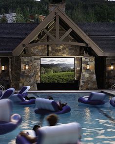 an outdoor movie is set up next to a pool with inflatable lounge chairs