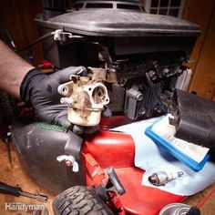 a man in black gloves is working on an engine and other parts that are underneath the car