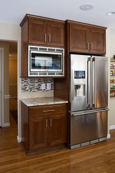 a stainless steel refrigerator freezer sitting in a kitchen next to wooden cabinets and drawers