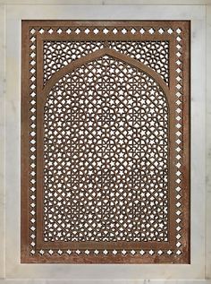 an intricately carved window in the middle of a wall