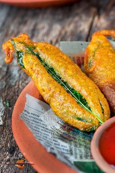 two fried food items on a plate with dipping sauce