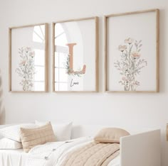 two framed pictures hang on the wall above a bed in a bedroom with white walls