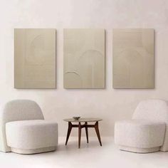 three white chairs and a table in a room