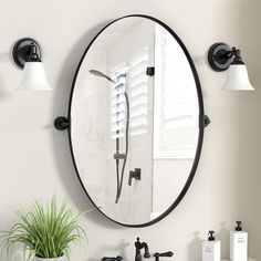 a bathroom with a round mirror and black faucet on the wall above it