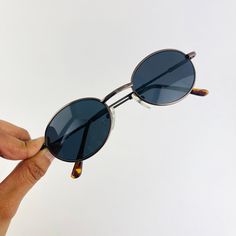 These round oval sunglasses are your everyday classic frames. Featuring a silver metal frame with black smoke lens. This style is unisex. True genuine vintage sunglasses from the 90s.  - 400 uv  Measurements: Lens height: 37mm Lens width: 51mm Bridge: 22mm Arm temple: 140mm Frame width: 133mm - new vintage from the 90s - includes sunglasses pouch Oval Sunglasses 90s, Sunglasses 90s, Sunglasses Pouch, Bronze Metal, Metal Sunglasses, Rectangle Sunglasses, Oval Sunglasses, Classic Frame, Sunglasses Vintage