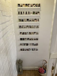 a white wall with several pictures on it and a basket of flowers in the corner