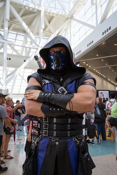 a man dressed as darth vader is standing in an airport with his arms crossed