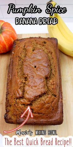 a loaf of pumpkin spice banana bread sitting on top of a cutting board next to two bananas