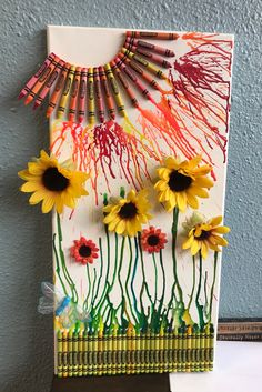 an art project with sunflowers and crayons on the side of a wall