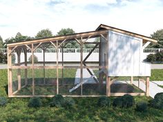 a chicken coop in the middle of a grassy area with trees and bushes around it