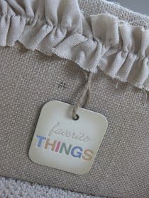 a tag that says favorite things hanging from the side of a bed frame with ruffles