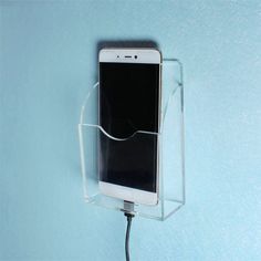 a cell phone is plugged into a charger attached to a wall with a cord