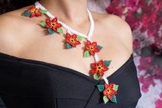 a woman wearing a necklace made with crochet flowers on it's neck