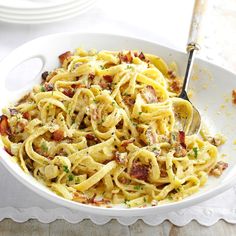 a white bowl filled with pasta and bacon