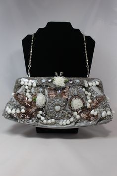 For your consideration is a Vintage Lexy International Inc. clutch style beaded handbag that dates to the mid 1900's. This clutch is in excellent condition (tag still attached) and is loaded with gorgeous rhinestones, beads, sequence and many other textiles and textures. The interior is lined with silver silk, the closure is a silver tone and rhinestone clasp and the clutch also comes with an attached silver toned chain for the option of wearing as a purse. This bag is perfect for a wedding, pro Vintage Party Clutch With Pearl Handle, Vintage Formal Clutch With Pearl Handle, Formal Vintage Evening Bag With Pearl Handle, Elegant Beaded Evening Bag For Vintage Events, Vintage Wedding Clutch Shoulder Bag, Vintage Pearl Handle Clutch Evening Bag, Vintage Evening Clutch With Pearl Handle, Vintage Handheld Evening Bag For Party, Vintage Silver Clutch For Events