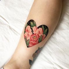 a heart shaped tattoo with flowers on it