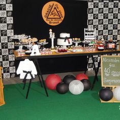 a dessert table is set up with black and white wallpaper, red ballons, and cake