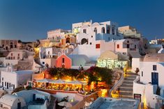 the city is lit up at night with colorful buildings