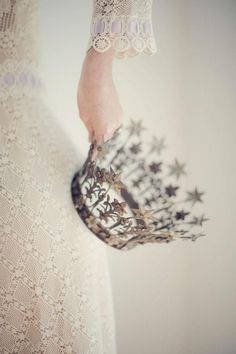 a woman's hand holding a bouquet of flowers in her left arm, against a white background