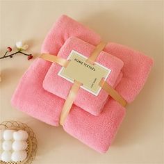 three towels wrapped in pink with a ribbon