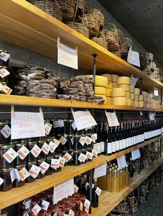 shelves filled with lots of different types of food and condiments on wooden shelves