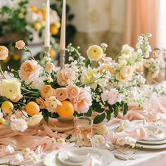 the table is set with flowers and candles