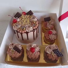 a box filled with lots of cupcakes covered in frosting and toppings