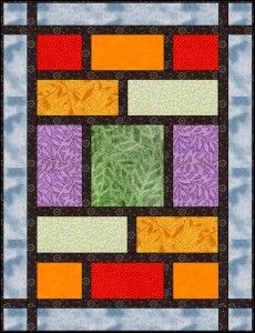 a colorful quilt hanging on the side of a wall in front of a black frame