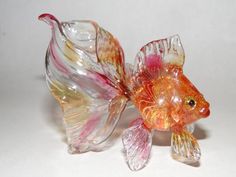 a glass fish figurine sitting on top of a table