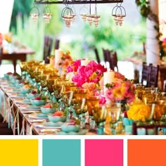 an image of a table setting with flowers and candles on it, in shades of pink, orange, yellow and green