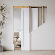 an open door leading to a bedroom with a plant in the corner next to it