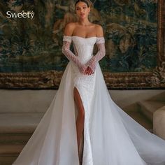 a woman in a white wedding dress posing for the camera with her leg slit down